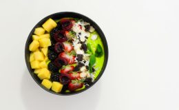 Delicious mixed fruit bowl with mango, blackberry, and cherry atop a creamy base. Perfect for a healthy diet.