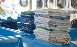 a stack of folded shirts sitting on top of a blue table